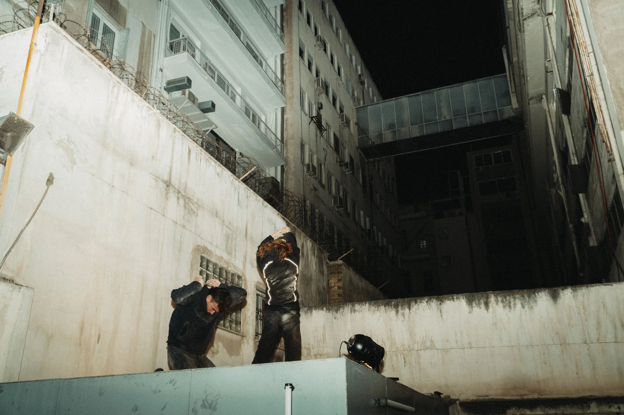 Two performers stand high in the architectural space of OPBO Gallery.
