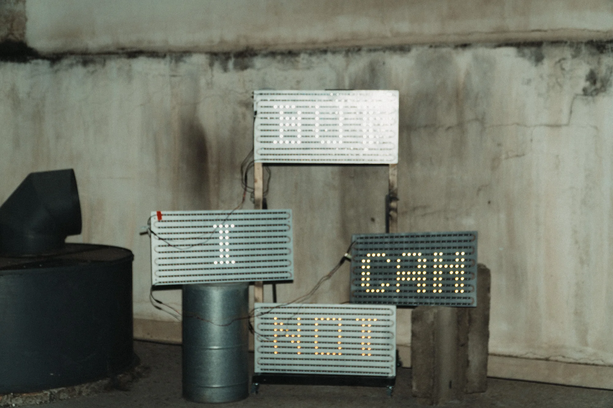 DIY LED panels arranged against a concrete wall.