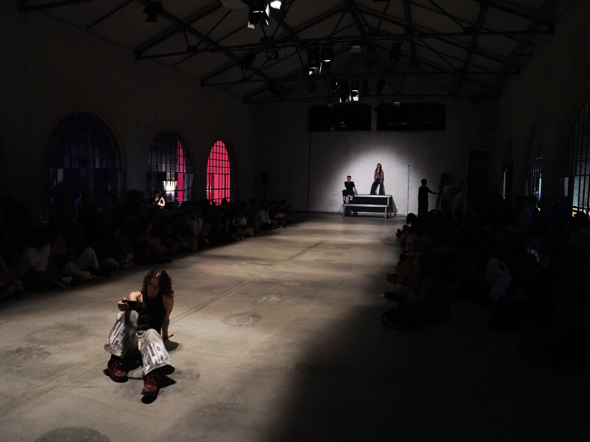 Three performers dispersed along the length of Sala Comando, with spectators seated at either side.