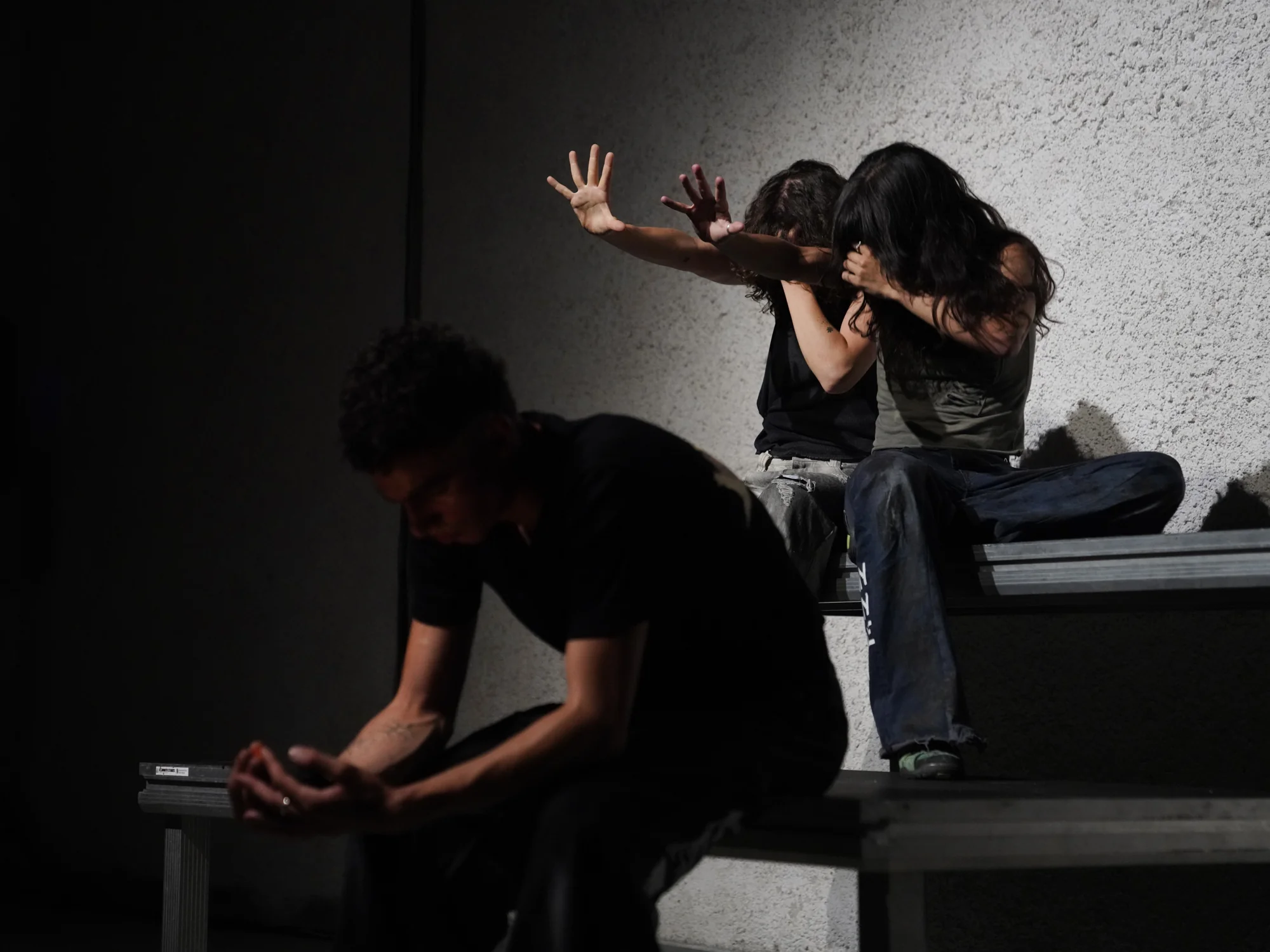Three performers gathered around a phone beside the platforms.