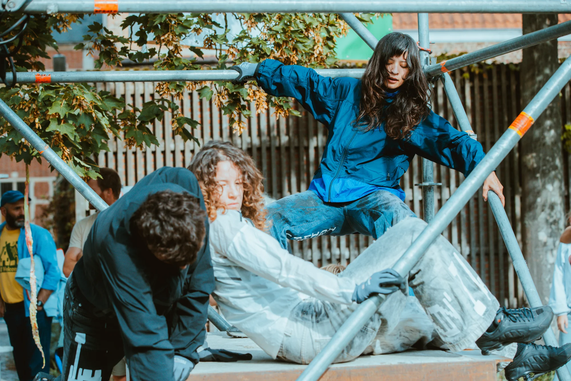 Performers assemble a tableau across the scaffolding platforms.