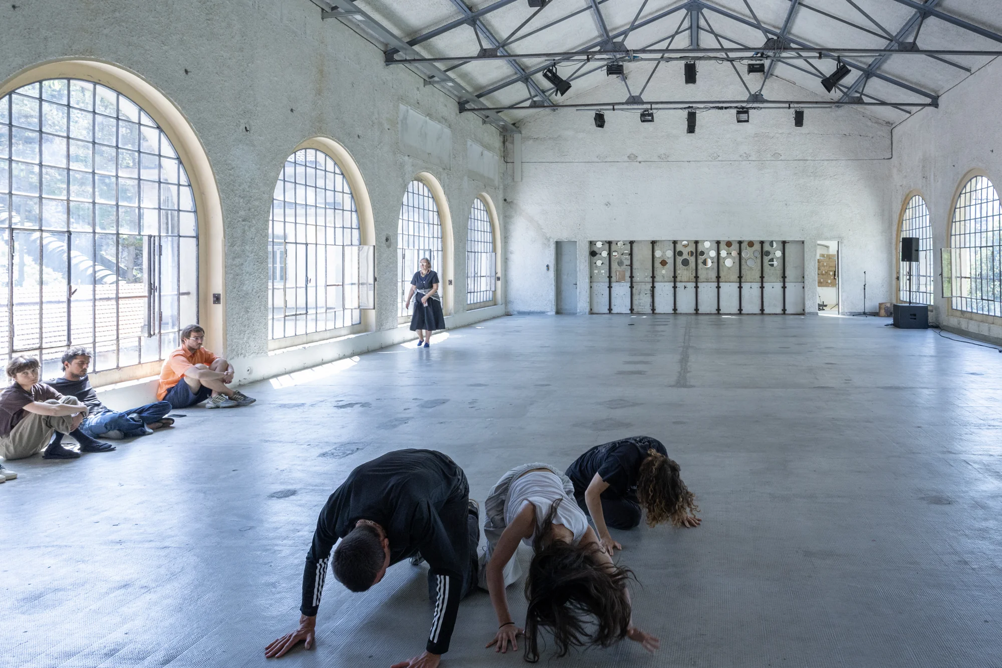 Three performers close to the floor in the daylight of Sala Comando.